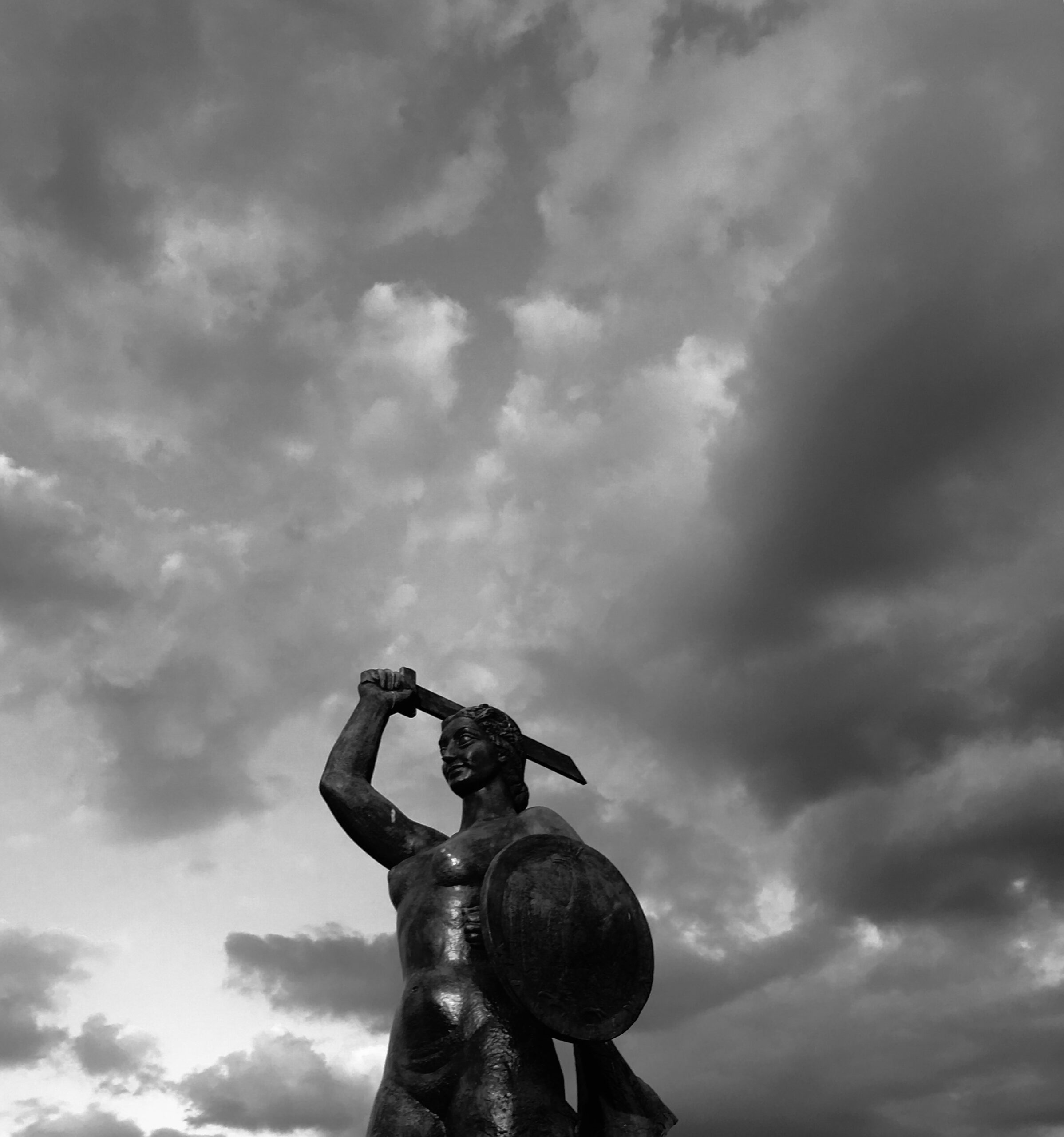 A vertical closeup of a person cleaning the window with a red squeegee
